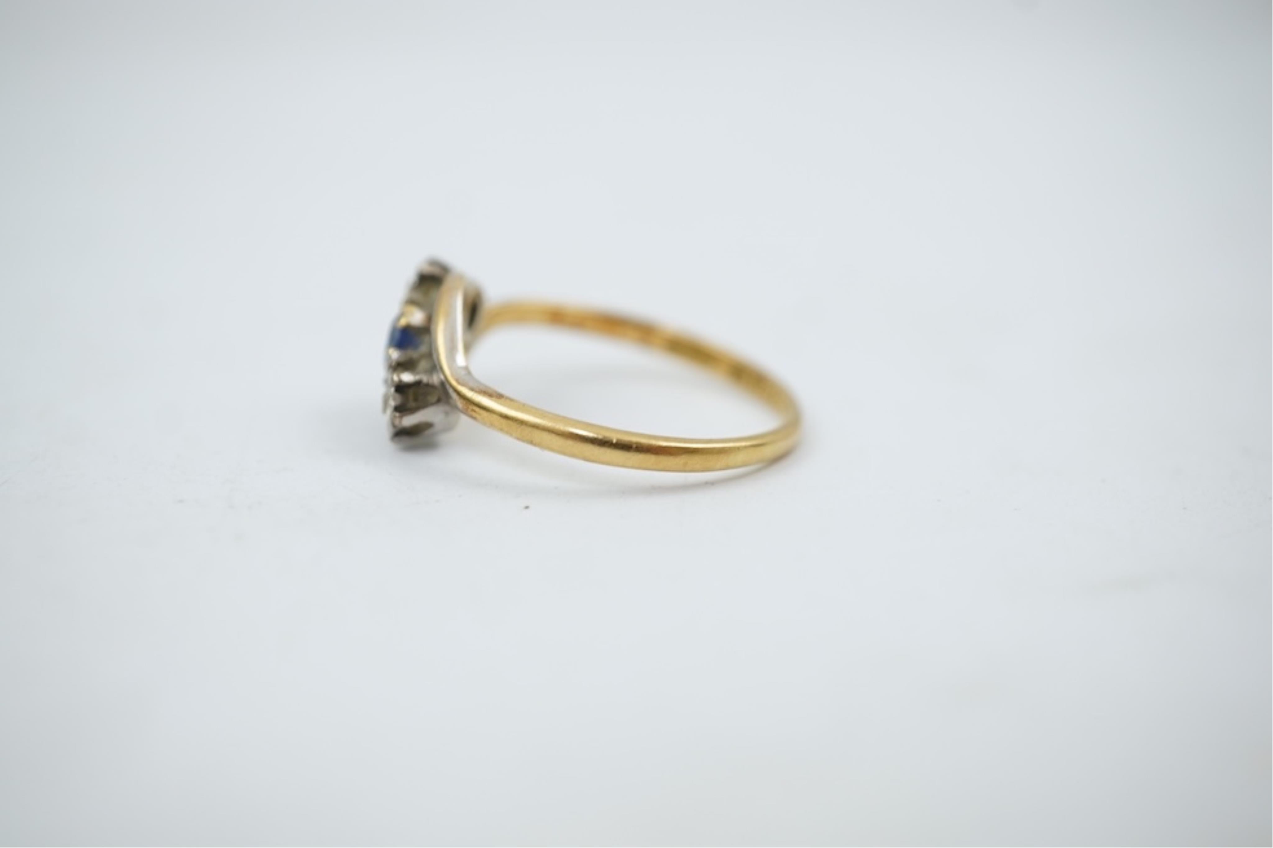 An early 20th century 18ct gold, sapphire and diamond set three stone crossover ring, size P/Q, gross weight 2.4 grams.